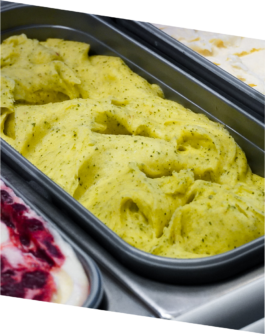 Grünes Eissorbet wird in einer Eisschale in der Vitrine präsentiert