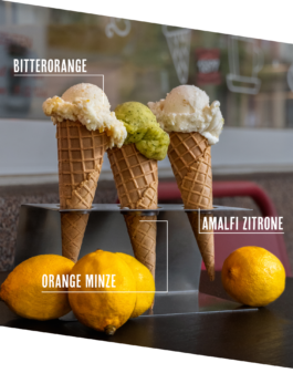 Drei Eiswaffeln mit je einer Eissorte werden auf dem Tresen präsentiert