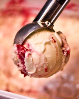 Leckere, cremige Eiskugel vom Heidelbeer-Sahne-Eis, die frisch aus der Eistruhe geschöpft wurde